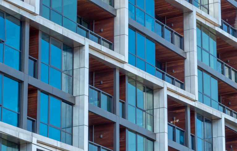 Close up of windows and balconies of a modern multi dwelling building of strata title living scheme.